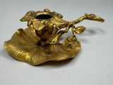 a gold plate with a flower on it on a table