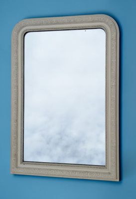 the mirror is hanging on the wall above the blue wall
