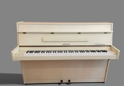 a white piano that is sitting on a gray surface