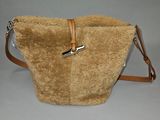 sac à main beige avec une bandoulière et une poignée en cuir marron sur fond gris