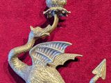 a metal dragon holding a bell on a red surface
