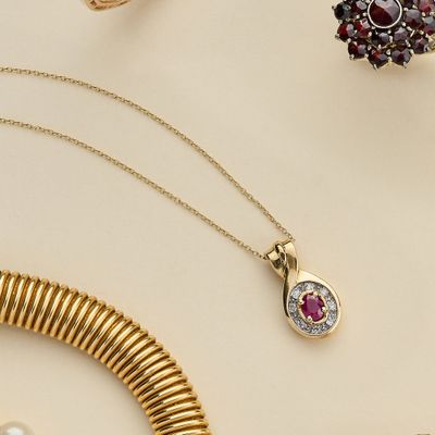 des colliers, des bracelets et des bagues en or et en grenat posés sur une table
