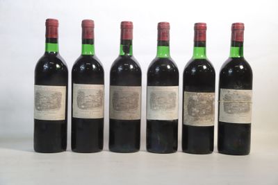 six bottles of wine are lined up on a white surface