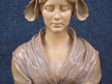 a statue of a woman with a hat on her head