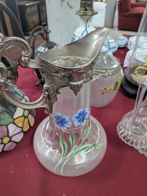 un vase en verre orné d'un oiseau, posé sur une table