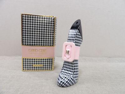un flacon de parfum en forme de chaussure à côté d'une boîte de parfum