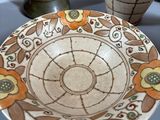 three vases and a plate sitting on a table