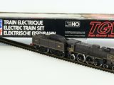 un petit train qui se trouve sur les rails, à côté d'une boîte