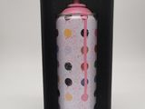 une canette de soda dans une boîte noire avec un couvercle rose