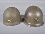 pair of wwii era british steel helmets with anchor and anchor decals