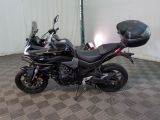a black motorcycle parked in a room with a checkered floor