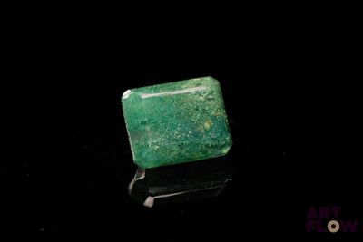 un gros plan d'une émeraude verte sur une surface noire