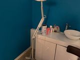 une pièce dans laquelle se trouvent une chaise, un lavabo et une lampe