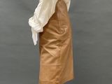 a mannequin mannequin wearing a tan skirt and white shirt
