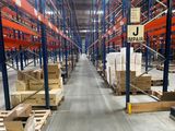 un grand entrepôt rempli de cartons et de palettes
