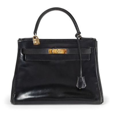 un sac à main en cuir noir avec des ferrures dorées sur la poignée