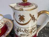a red and white tea pot with a gold decoration