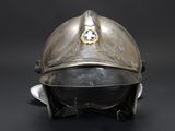 an old silver helmet with a blue cross on the side