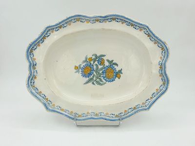 une assiette blanche décorée de fleurs bleues et jaunes