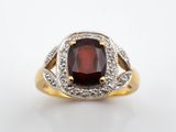 un gros plan d'une bague ornée d'un grenat entouré de diamants