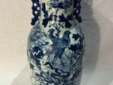 a blue and white vase with a bird on it