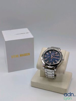 the watch is sitting on the stand next to the box