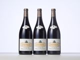 three bottles of wine are lined up on a table