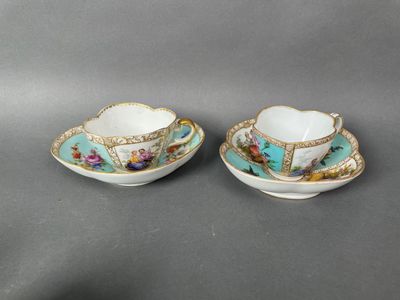 a pair of tea cups and saucers decorated with flowers