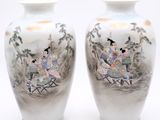 two vases with asian paintings on them sitting on a table