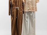 deux mannequins vêtus de tenues marron et blanches, posés sur un présentoir à mannequins