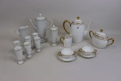 a white and gold tea set with cups and saucers