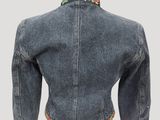 the back of a denim jacket with a floral design on the collar