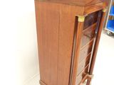 a small wooden cabinet with drawers in the corner of the room