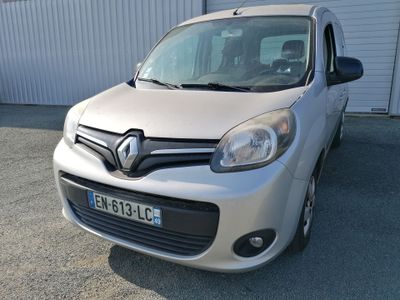 une petite voiture argentée garée devant un immeuble