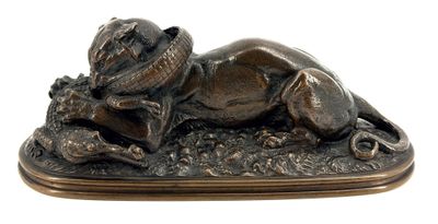 bronze statue of a dog laying down on the ground with a hat on it ' s head