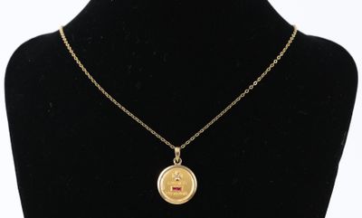 un collier plaqué or avec une petite pièce suspendue à une chaîne