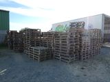 de nombreuses palettes en bois empilées les unes sur les autres devant un camion