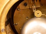 a close up of a clock with a metal ball in it