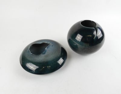deux vases noirs posés sur une surface blanche
