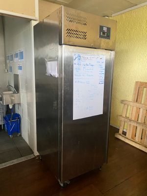 une photo d'un réfrigérateur dans une cuisine, avec un tableau blanc sur la porte