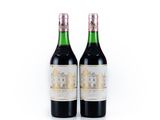 deux bouteilles de vin posées l'une à côté de l'autre sur une surface blanche