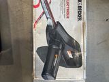 une boîte contenant un outil Black & Decker posée par terre
