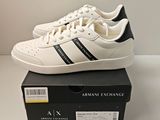 an image of a pair of white and black sneakers on top of a box
