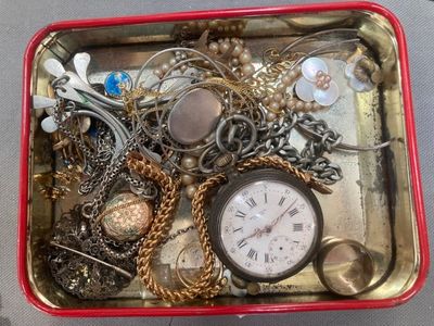 a red box filled with assorted jewelry on a table