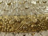 a gold chandelier with crystal beads hanging from it ' s ceiling