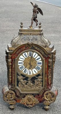 une horloge surmontée d'une statue, dans la rue