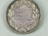 a silver medal with a blue ribbon around it