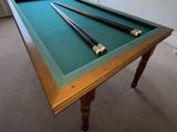 a pool table with two cues on top of it