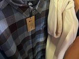 a woman that is looking at some clothes on a rack