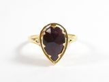 gros plan d'une bague en or avec une pierre rouge
